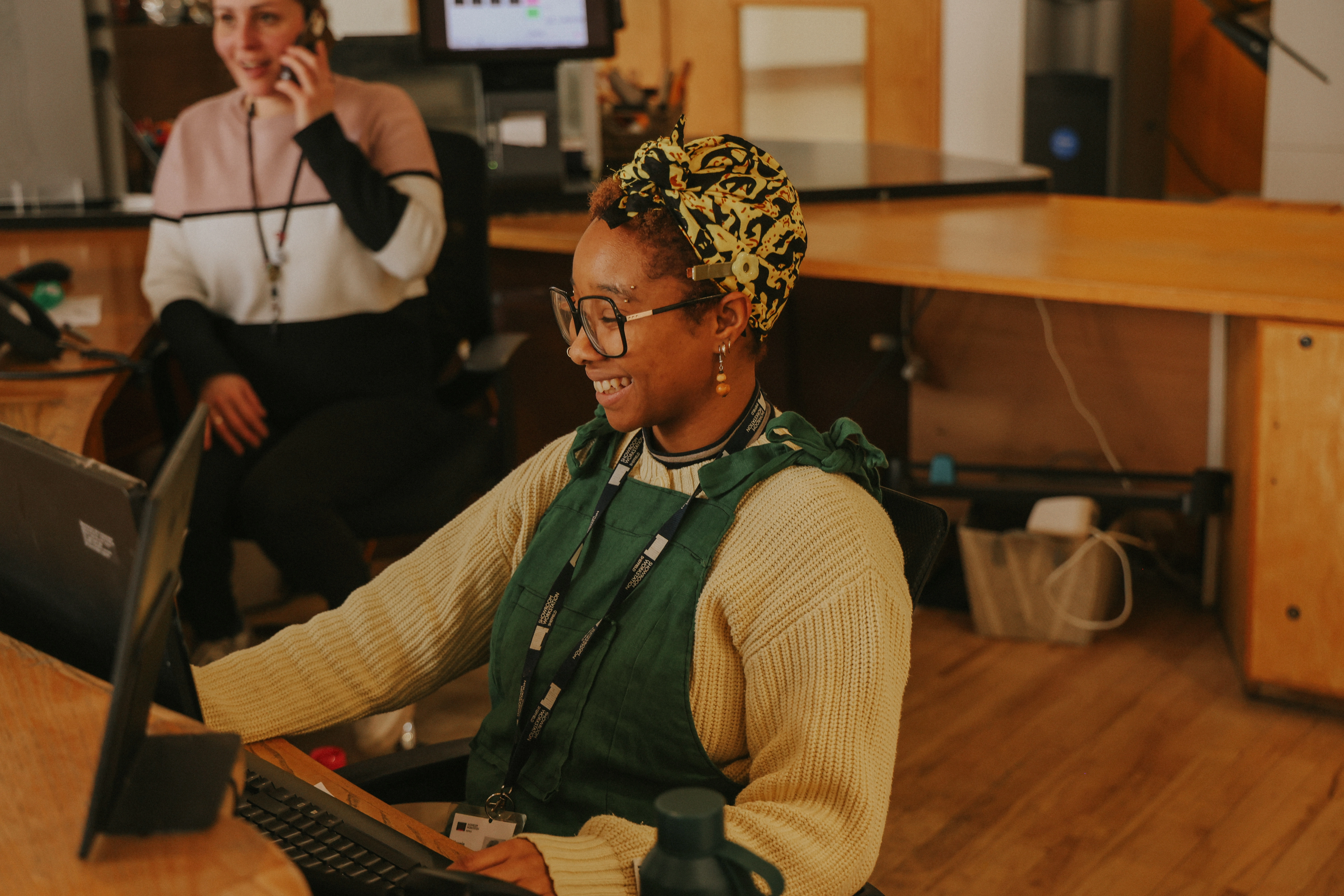 Woman smiling at computer inside The Work Station