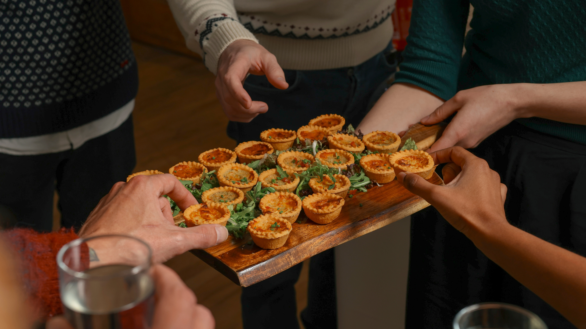 Hands grabbing different nibbles off a platter