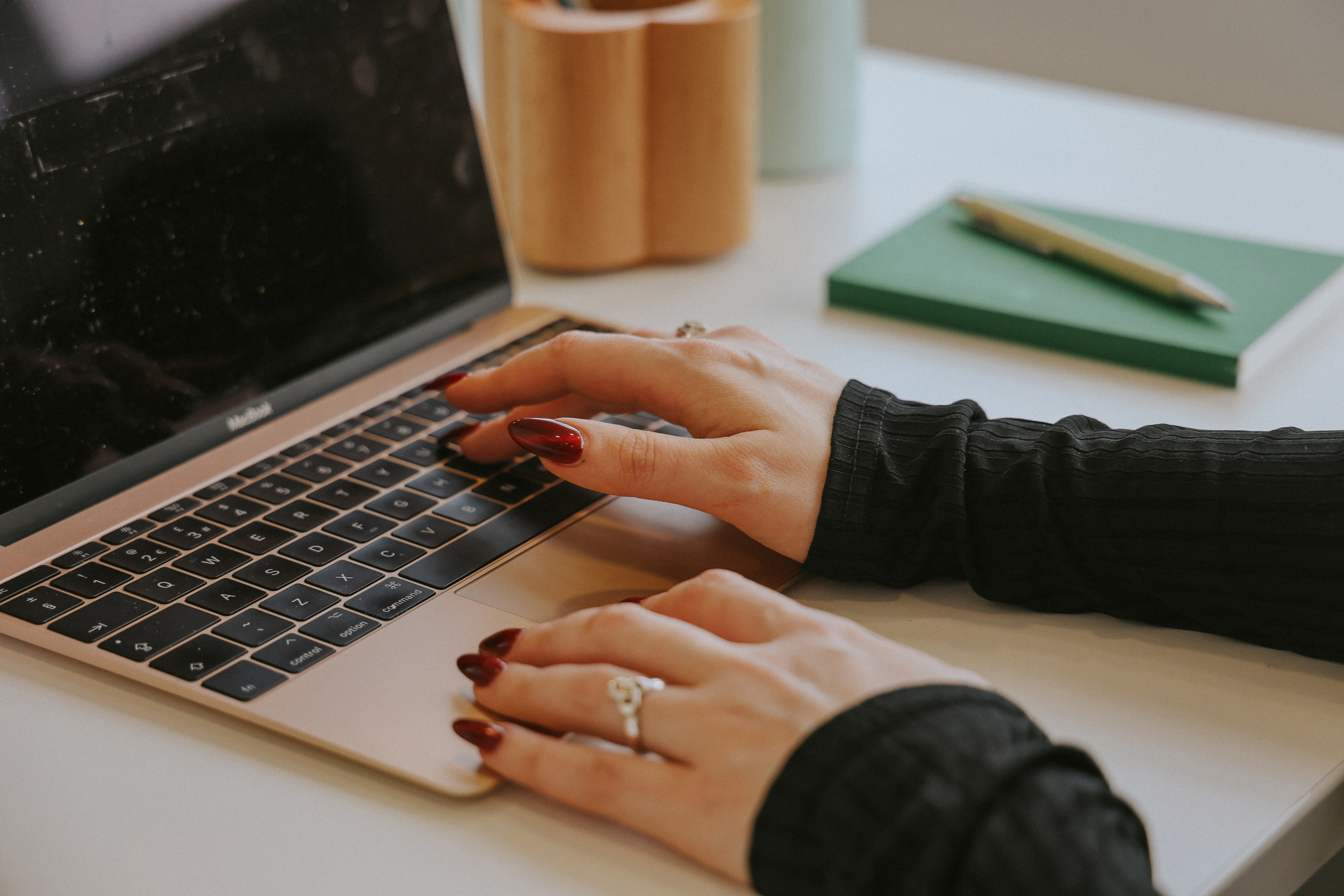 A woman types on a laptop keyboard